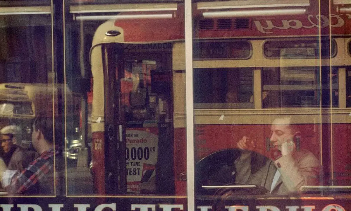 Un uomo al telefono, riflesso su una vetrina, evoca l'atmosfera urbana di Saul Leiter.