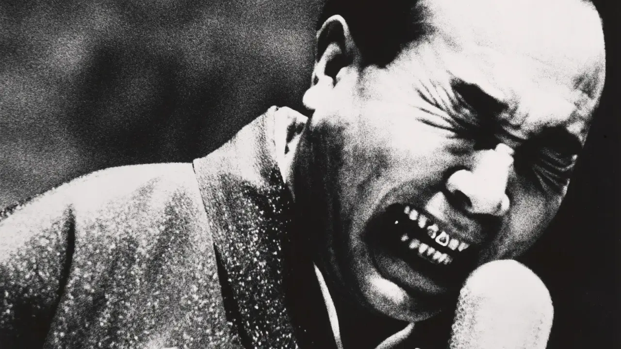 Un uomo con gli occhi chiusi e la bocca spalancata in un grido, un'espressione intensa catturata da Daidō Moriyama.