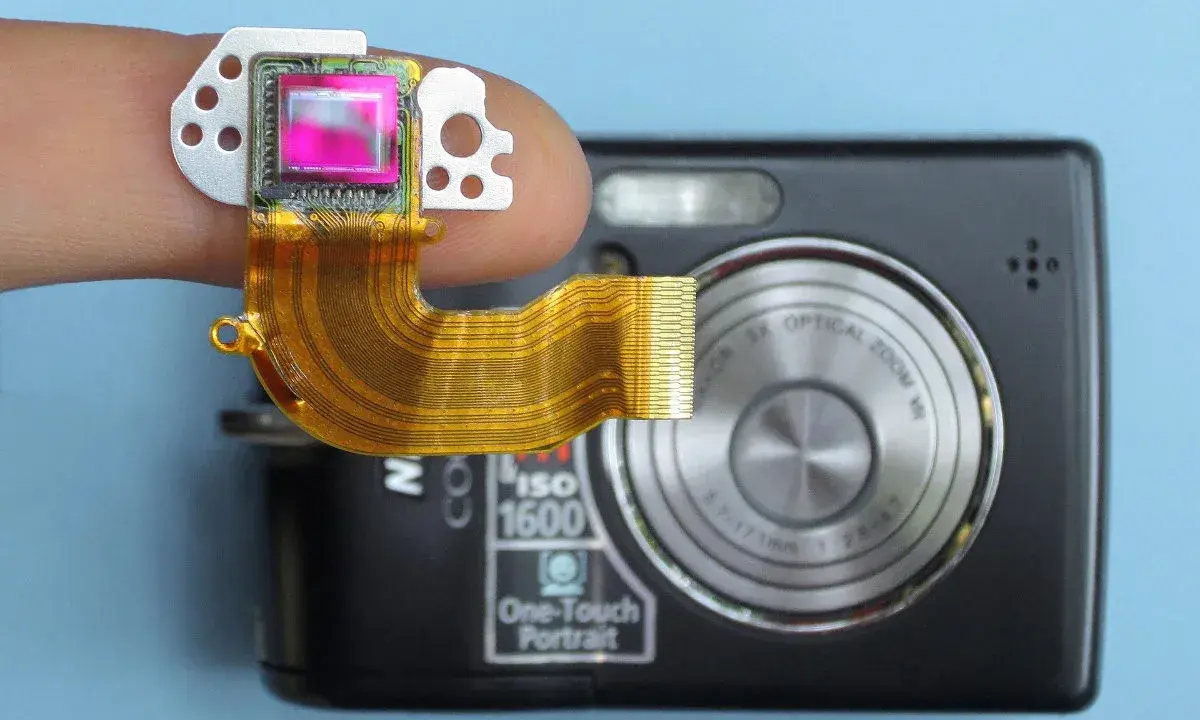 Dito un sensore fotocamera su un dito, collegato a una fotocamera compatta.