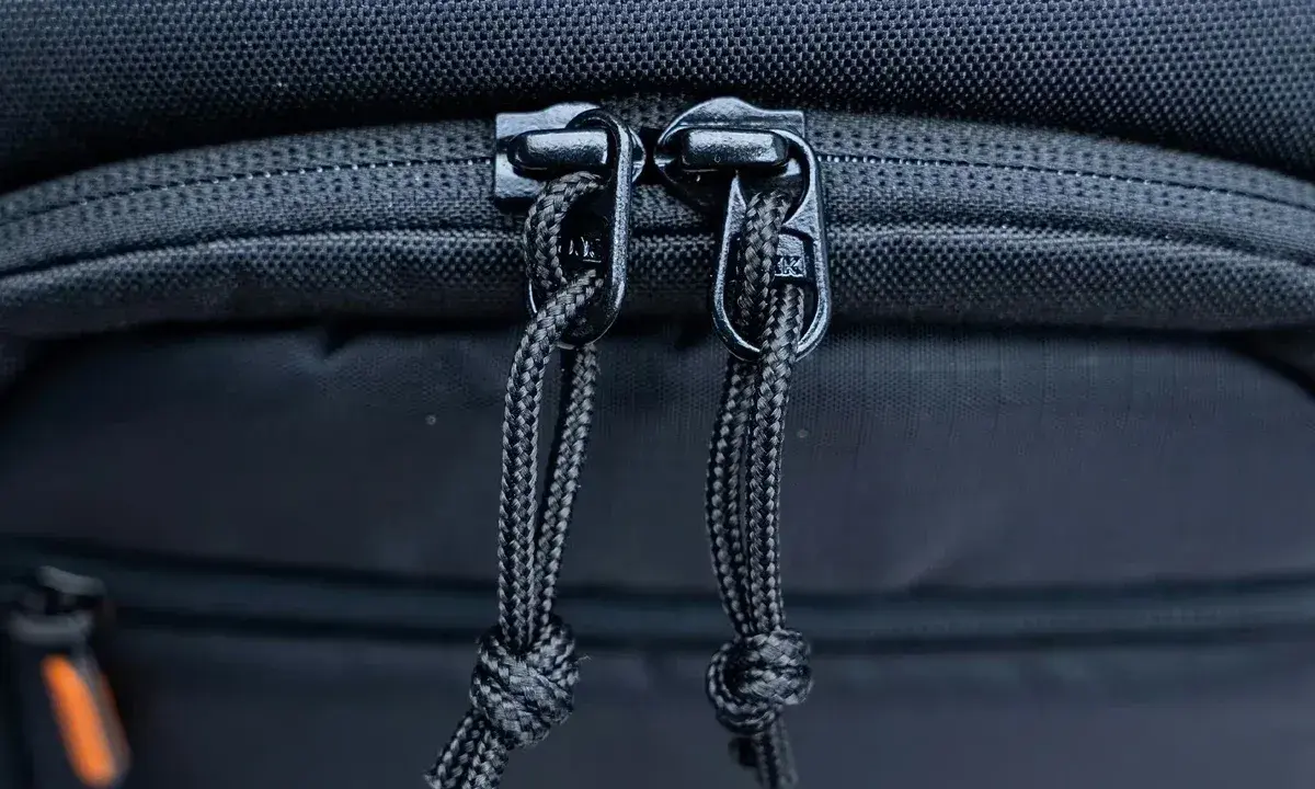 Dettaglio cerniere con cordini di un zaino fotografico Lowepro, pronto per proteggere la tua attrezzatura.