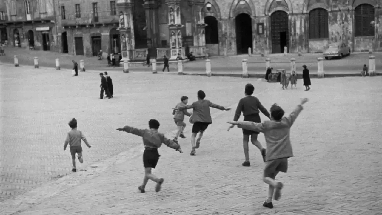 Bambini giocano in una piazza, un momento di street photography famosi.