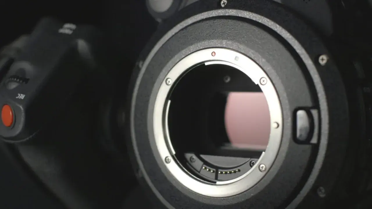 Dettaglio di una fotocamera con attacco obiettivo aperto, mostrando i contatti per i sensori digitali.