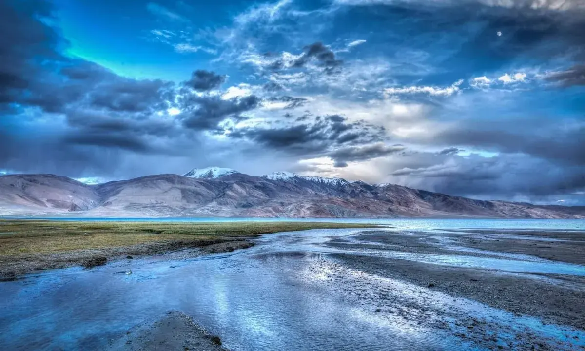 Paesaggio montano con lago e cielo drammatico. L'effetto HDR esalta i colori e i dettagli, un sì deciso per questa immagine.