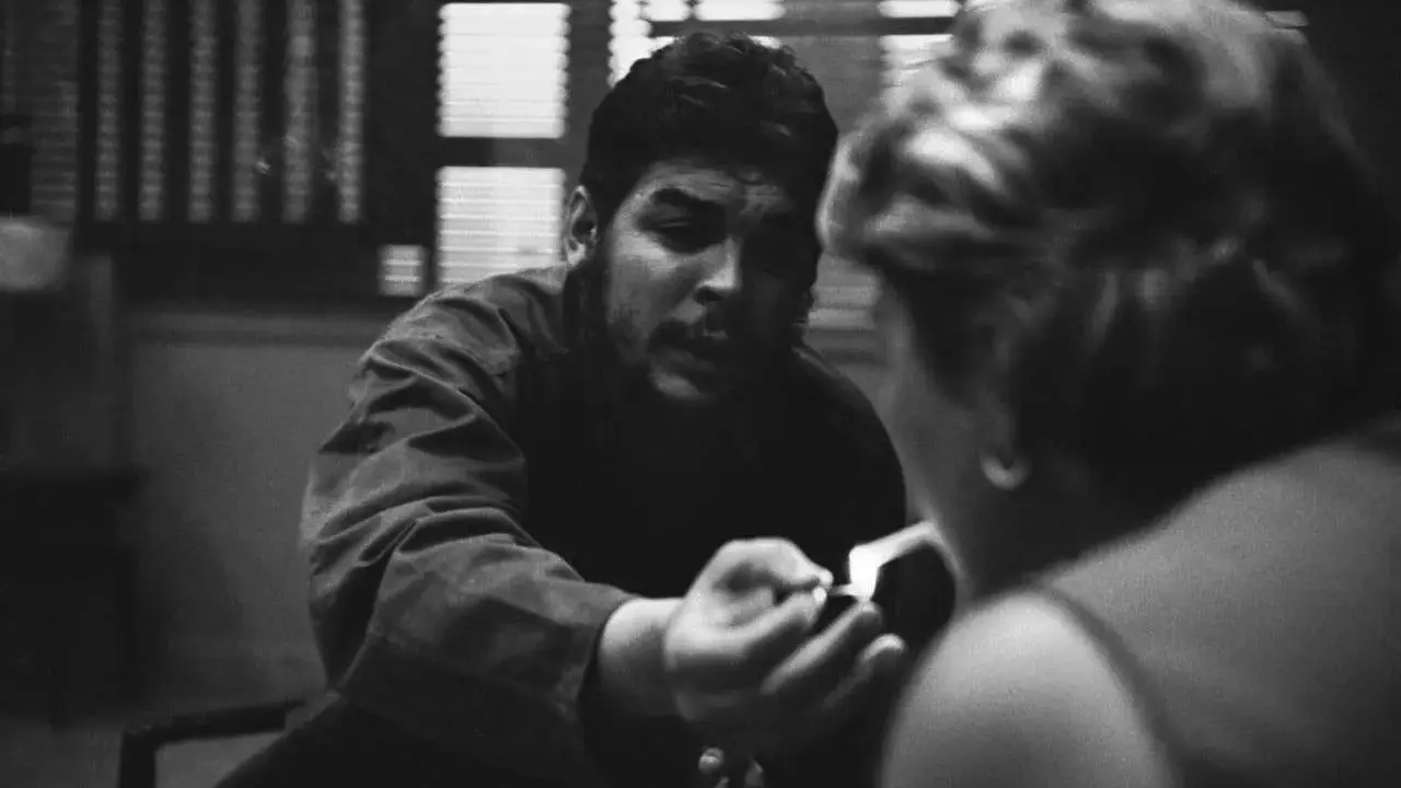 Un uomo con barba e baffi, forse Che Guevara, accende una sigaretta, catturato da rene burri.