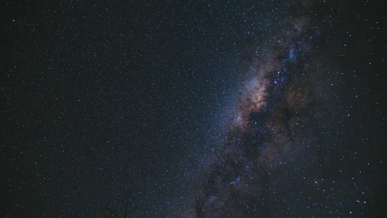 Una foto al cielo notturno, con la Via Lattea che brilla tra innumerevoli stelle.