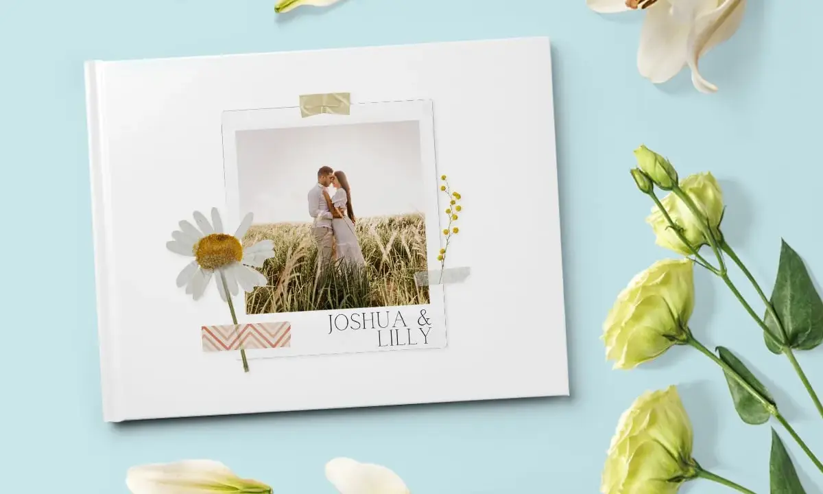 Come creare album foto personalizzato: un libro bianco con foto di coppia, margherita e fiori.