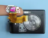 Dito un sensore fotocamera su un dito, collegato a una fotocamera compatta.