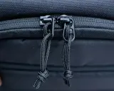 Dettaglio cerniere con cordini di un zaino fotografico Lowepro, pronto per proteggere la tua attrezzatura.