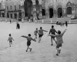 Bambini giocano in una piazza, un momento di street photography famosi.