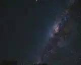 Una foto al cielo notturno, con la Via Lattea che brilla tra innumerevoli stelle.