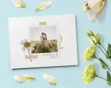 Come creare album foto personalizzato: un libro bianco con foto di coppia, margherita e fiori.
