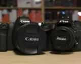 Due corpi macchina Canon e Nikon, uno accanto all'altro, pronti per catturare momenti.