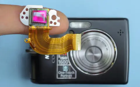 Dito un sensore fotocamera su un dito, collegato a una fotocamera compatta.