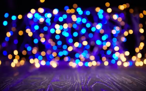 Luci sfocate blu e dorate creano un'atmosfera magica su uno sfondo scuro e un piano in legno viola.
