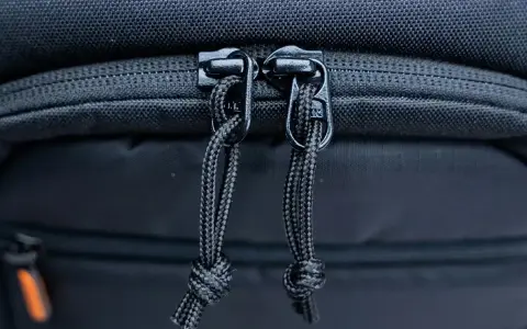 Dettaglio cerniere con cordini di un zaino fotografico Lowepro, pronto per proteggere la tua attrezzatura.