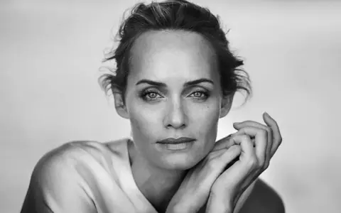 Ritratto in bianco e nero di una donna con le mani appoggiate al viso, un'espressione intensa. Un'opera di un fotografo ritrattista famoso.