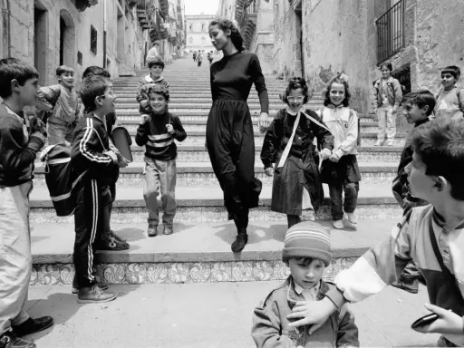 Bambini con zaini scendono una scalinata, accompagnati da una donna elegante. Un'istantanea che cattura la vivacità di queste fotografie famose.
