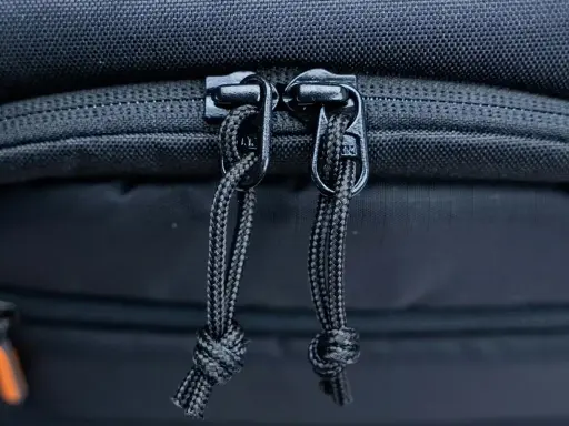 Dettaglio cerniere con cordini di un zaino fotografico Lowepro, pronto per proteggere la tua attrezzatura.
