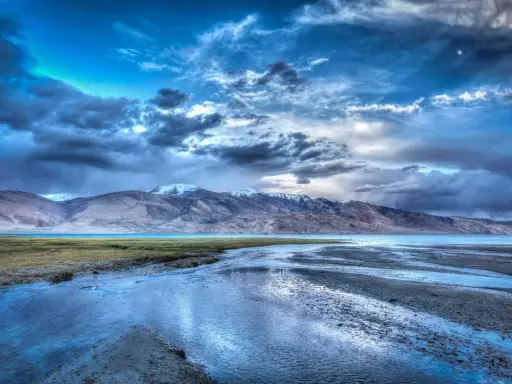 Paesaggio montano con lago e cielo drammatico. L'effetto HDR esalta i colori e i dettagli, un sì deciso per questa immagine.