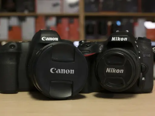 Due corpi macchina Canon e Nikon, uno accanto all'altro, pronti per catturare momenti.