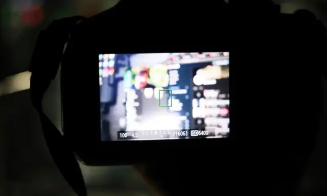 Schermo di una fotocamera con obiettivo Canon 18-55 che non mette a fuoco. L'immagine mostra un'area di messa a fuoco verde su uno sfondo sfocato.