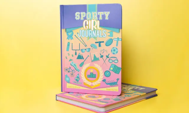 Come fotografare un libro: due quaderni "Sporty Girl Journals" con copertine colorate e illustrazioni sportive su sfondo giallo.
