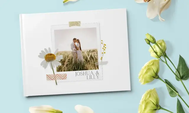 Come creare album foto personalizzato: un libro bianco con foto di coppia, margherita e fiori.