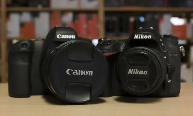 Due corpi macchina Canon e Nikon, uno accanto all'altro, pronti per catturare momenti.