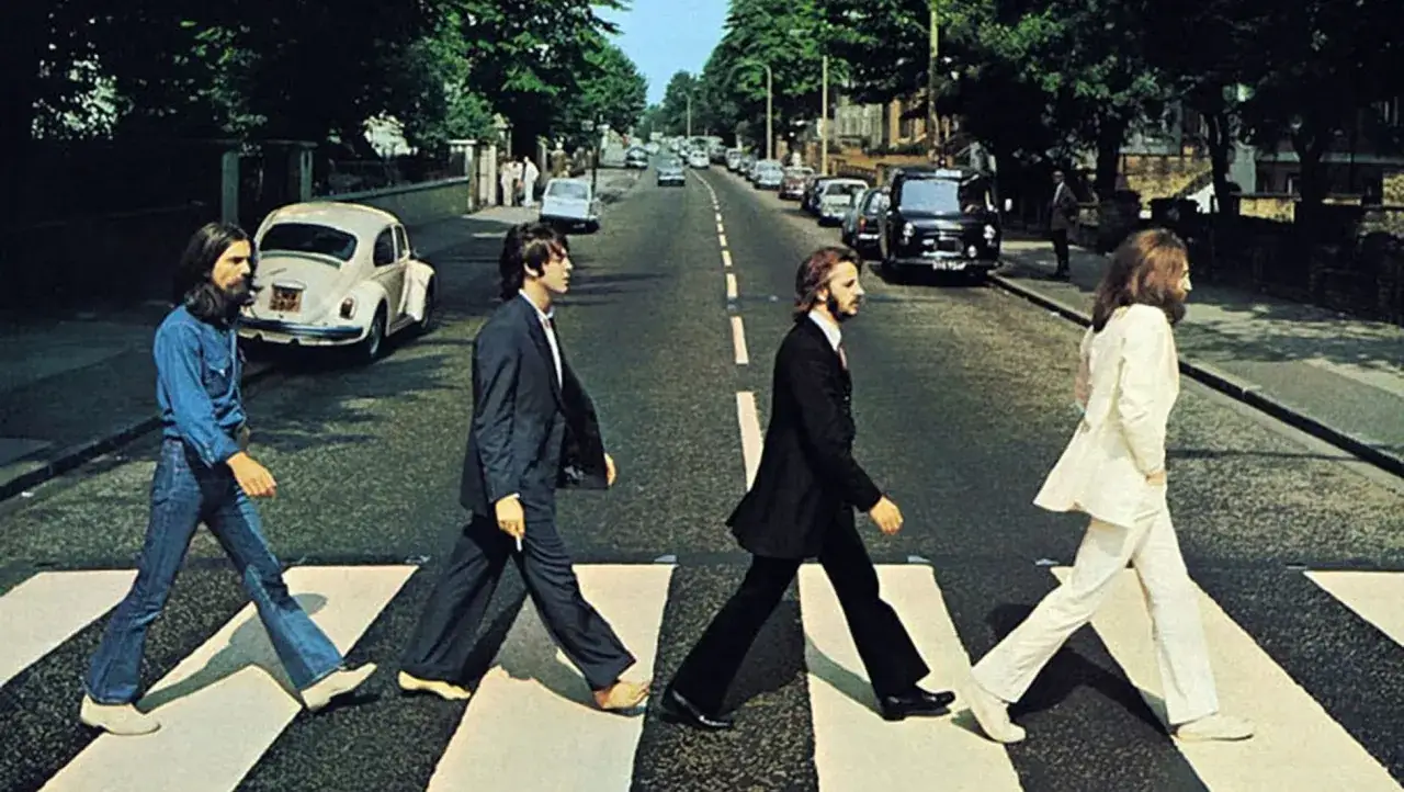 I Beatles attraversano Abbey Road, la foto pi&ugrave; famosa del mondo, in un'iconica passeggiata che ha segnato la storia della musica.