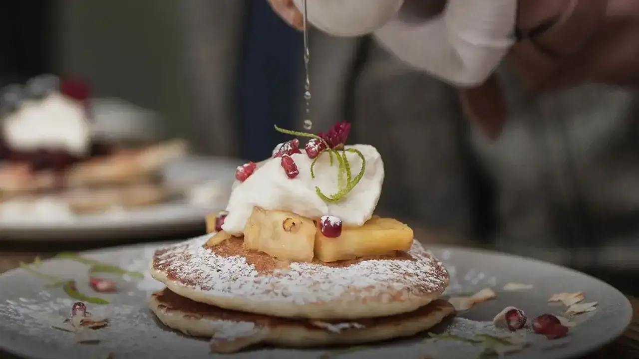 Pancakes con panna, frutta e melograno, un invito a fotografare il cibo per catturare la dolcezza.
