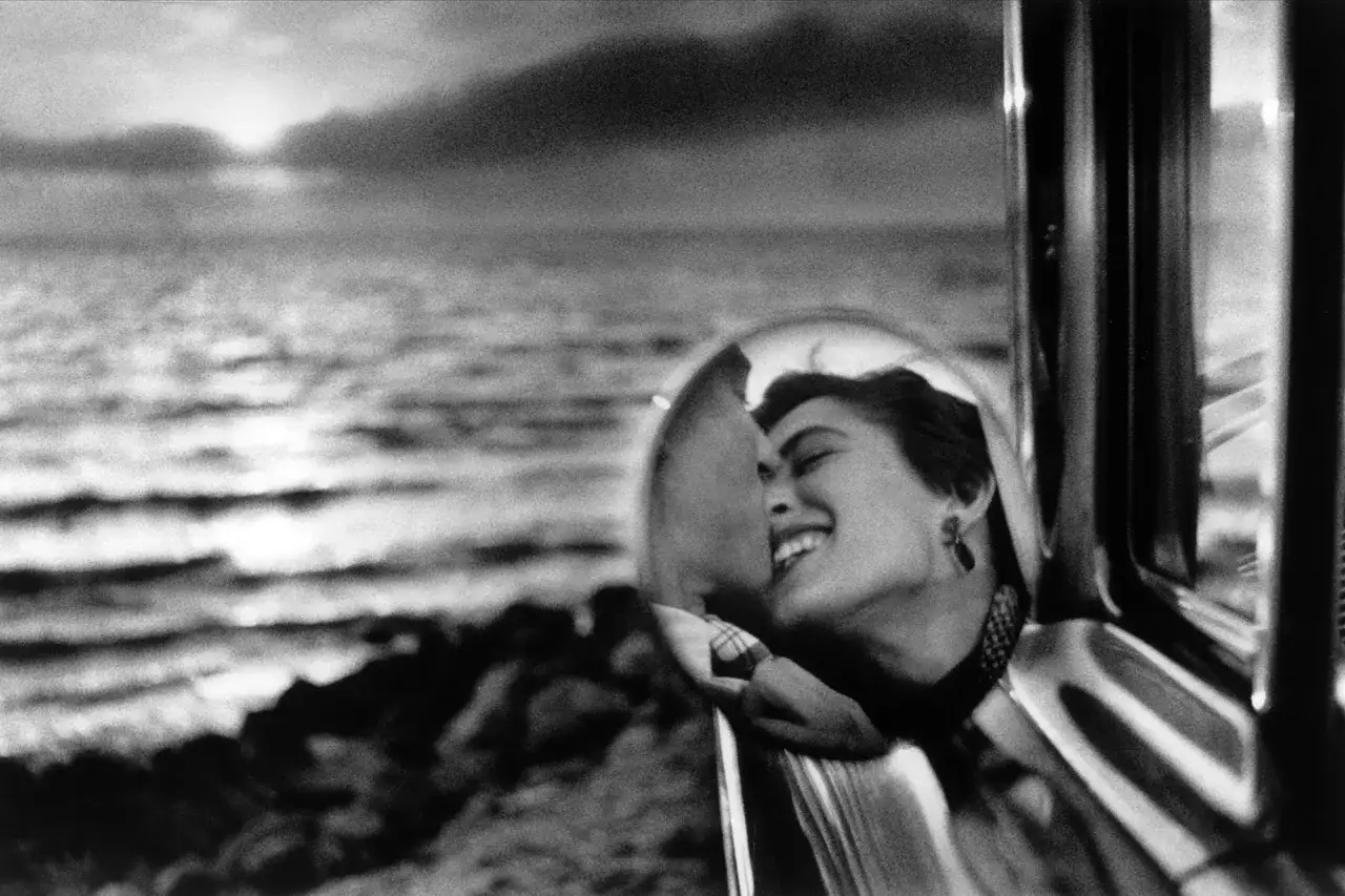 Un bacio rubato riflesso in uno specchietto, un'icona catturata da fotografi famosi. Mare e cielo sullo sfondo.