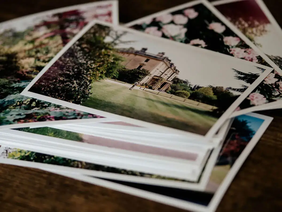 Pile di foto stampate su carta matte, con un palazzo e fiori. Il loro significato &egrave; legato ai ricordi preziosi.