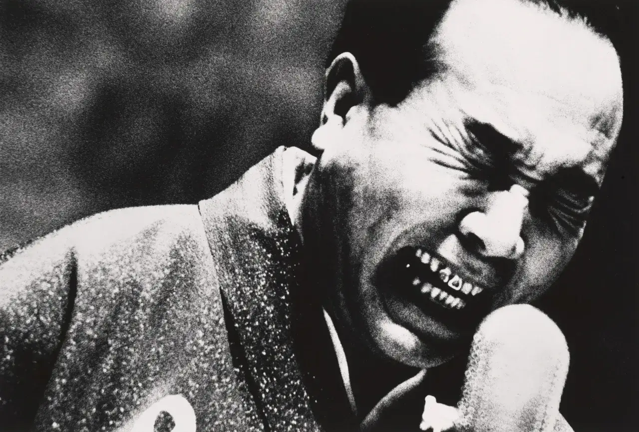 Un uomo con un'espressione di dolore intenso, tipica dello stile di Daidō Moriyama.