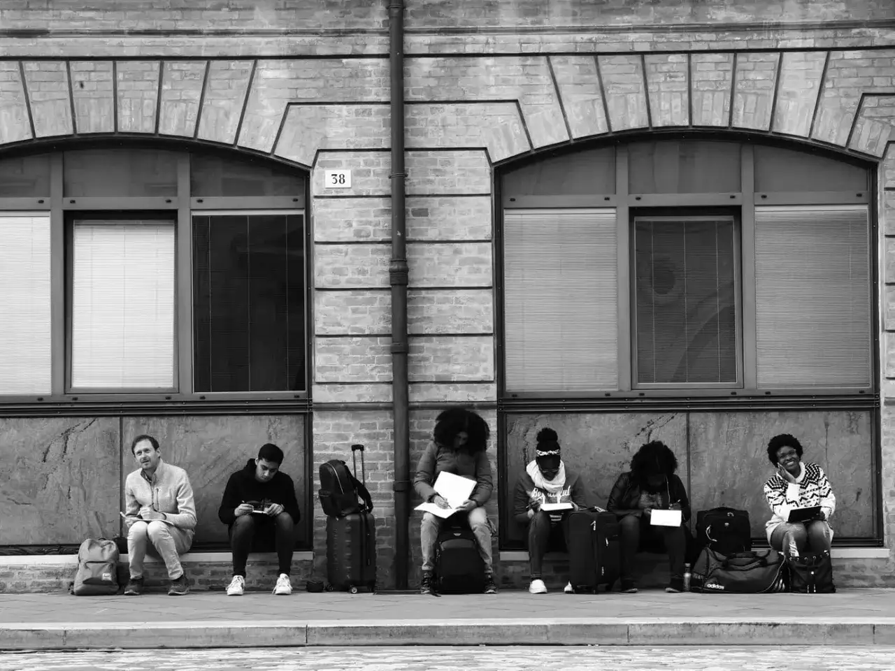 Persone in attesa, una fotografia minimalista che cattura un momento di quiete prima di un viaggio.