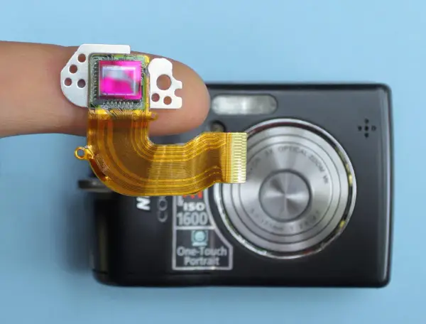Dito un sensore fotocamera su un dito, collegato a una fotocamera compatta.